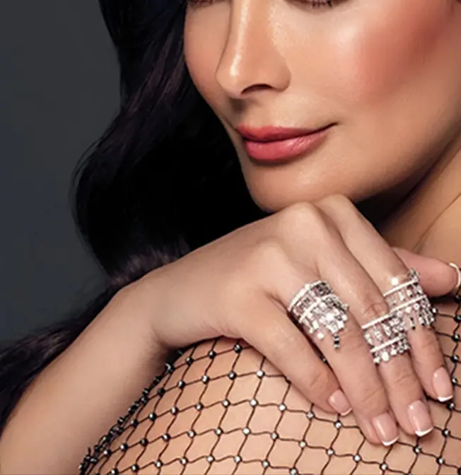 A woman wearing multiple rings with diamonds on her fingers.