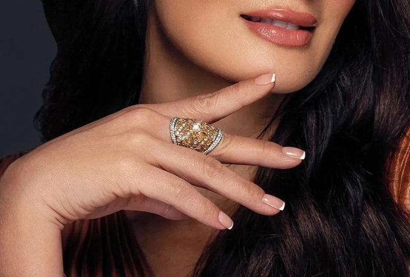 A woman with long, dark hair and wearing a ring.