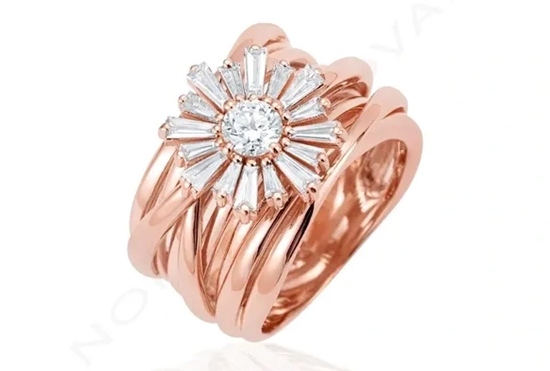 A rose gold ring with a flower design on it