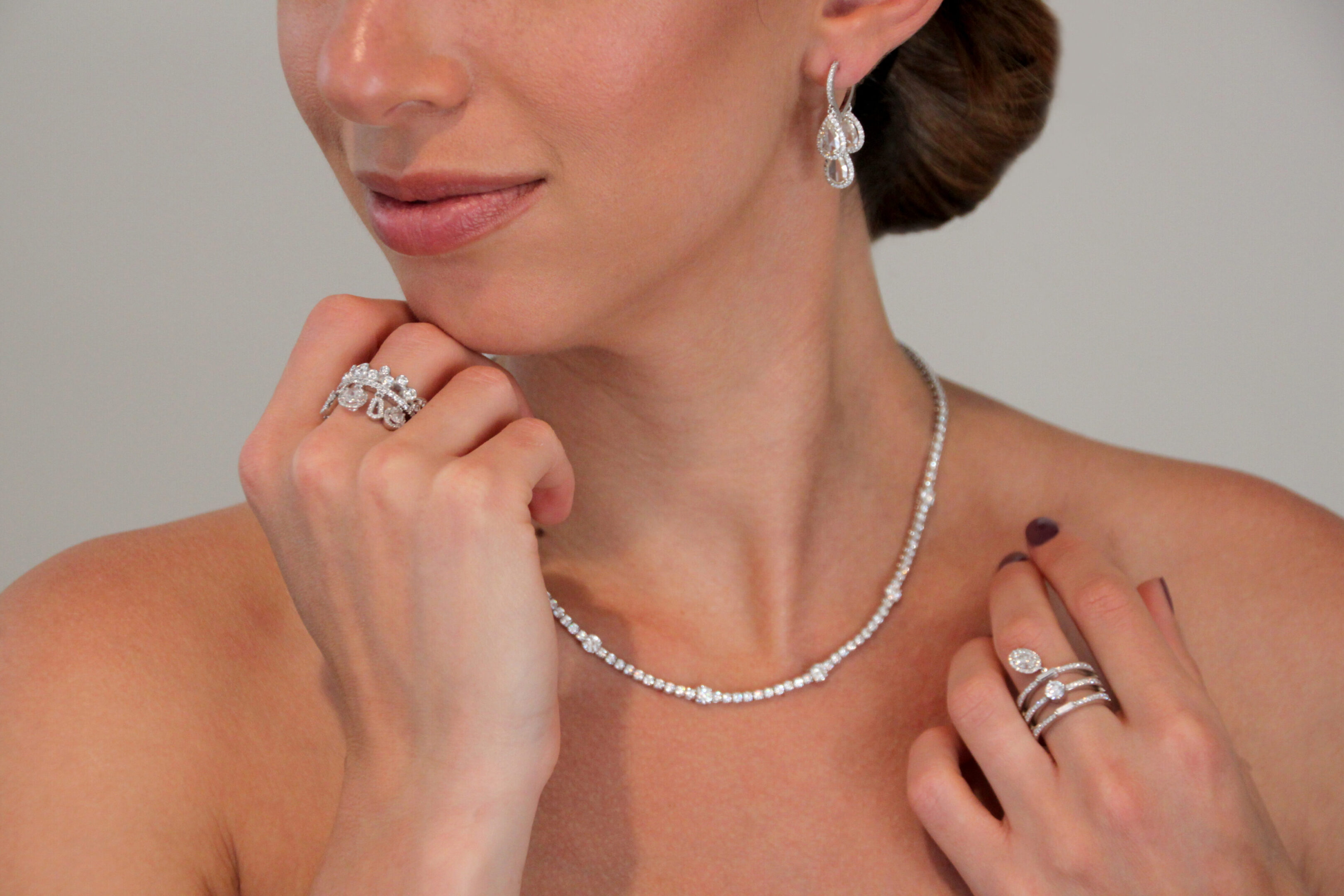 A woman wearing jewelry and looking at the camera.